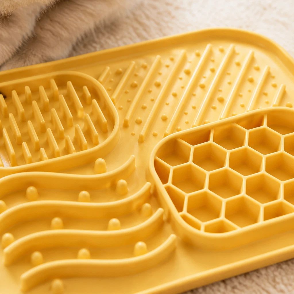 Close-up of the yellow silicone lick mat's raised textures and honeycomb section