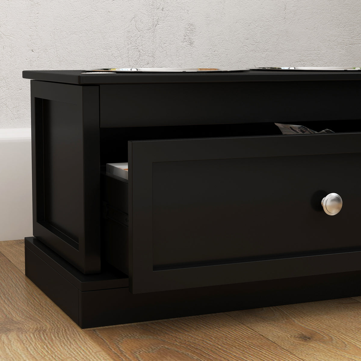 Close-up of the drawer and knob on a black raised dog bowl stand