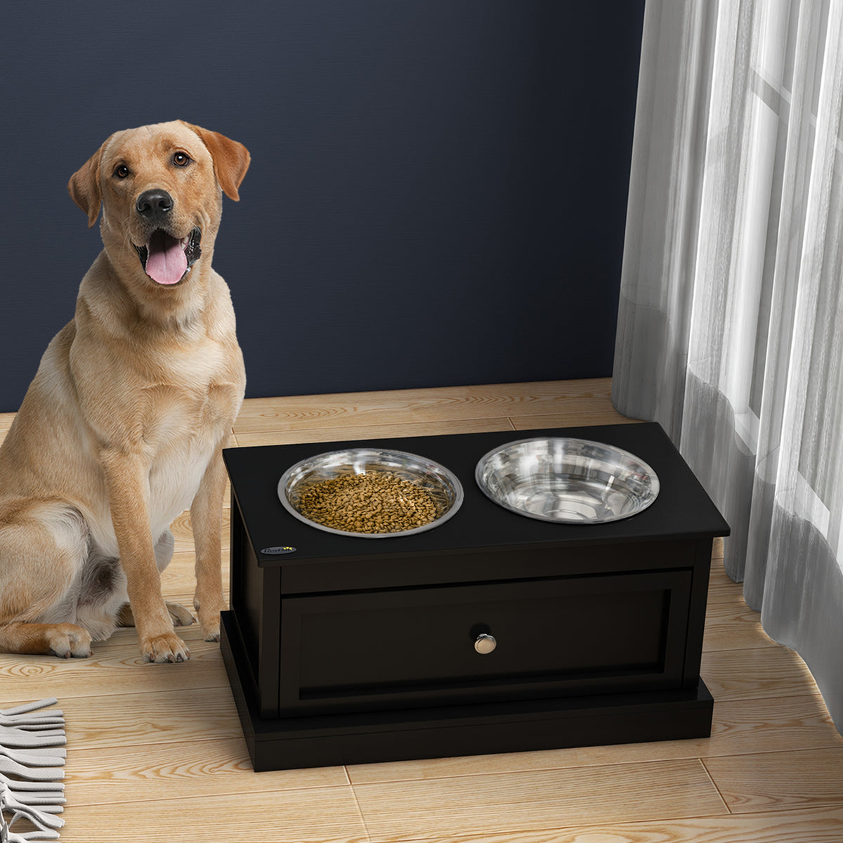 Labrador next to a black elevated dog feeder with kibble